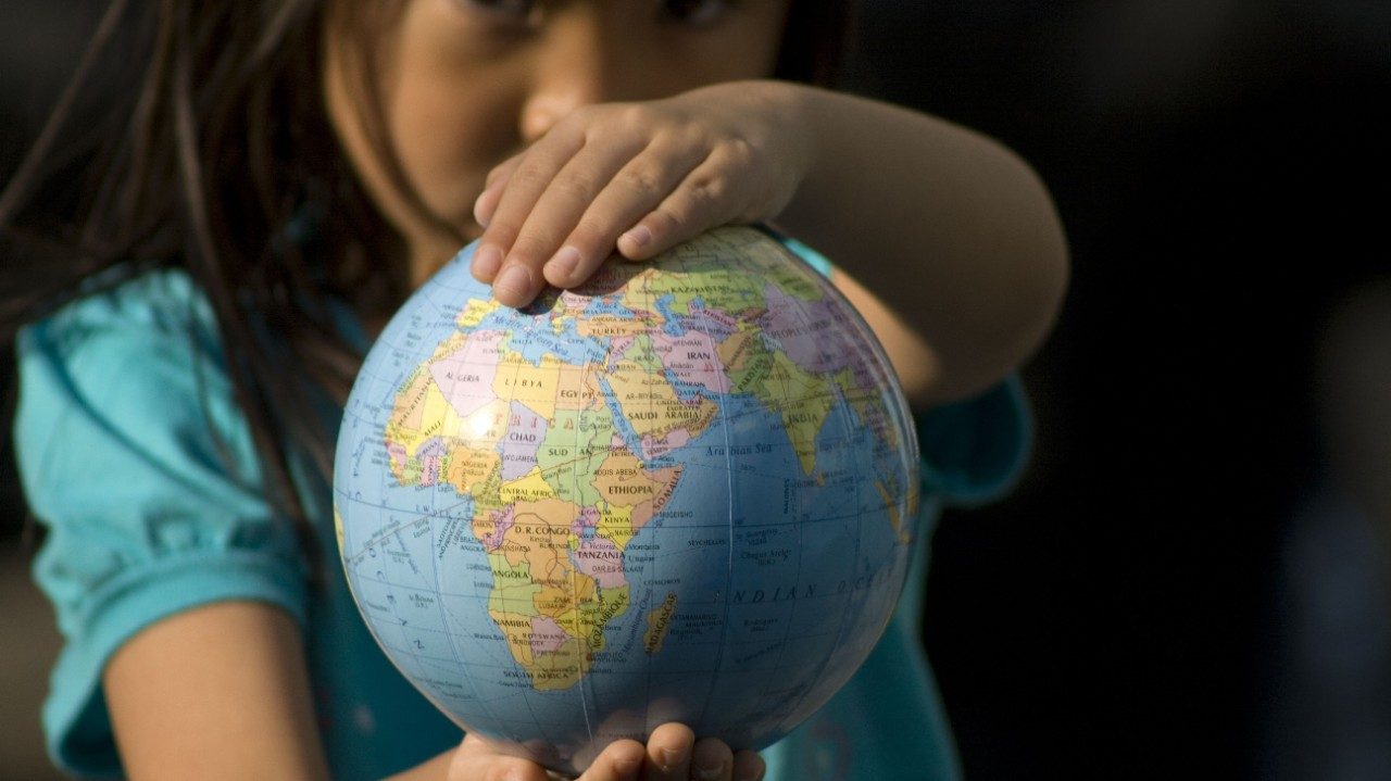 young girl holding globe