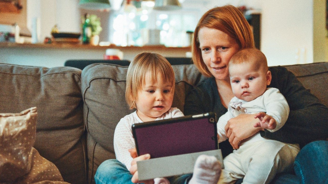 Mom sitting on a couch with two toddlers